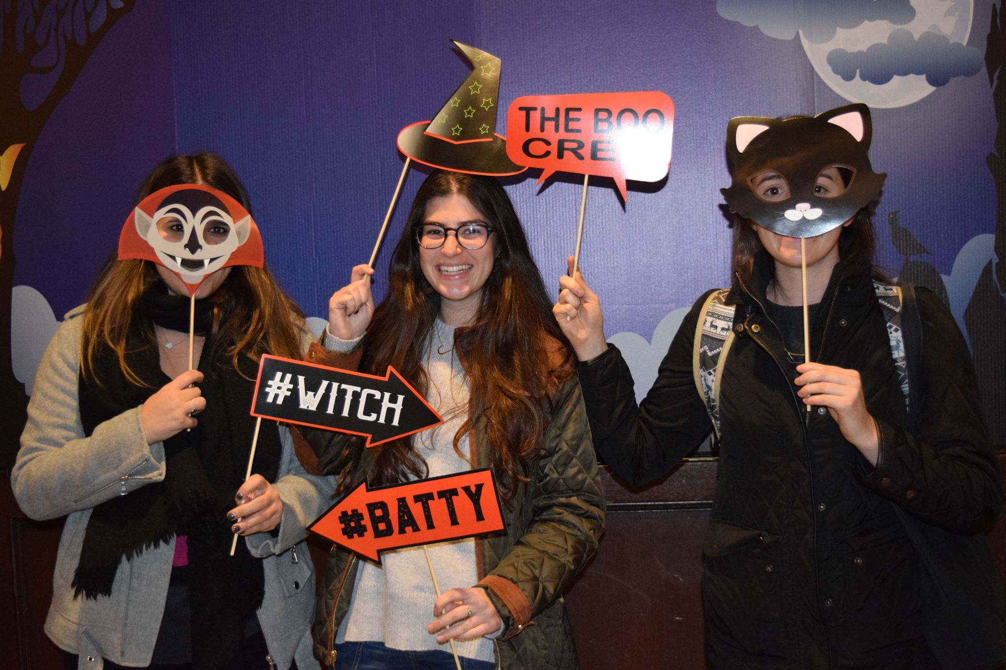 Penn students pose with halloween props in the halloween photo booth