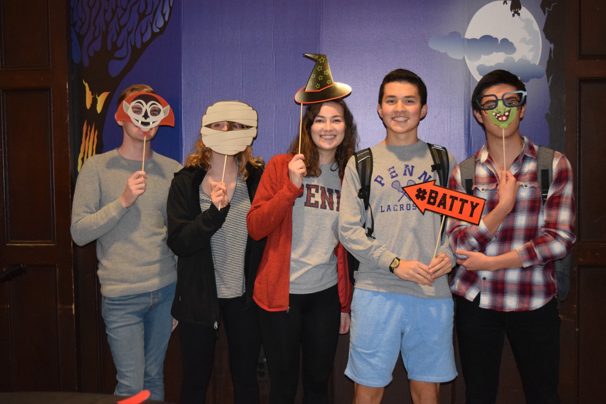 Penn Students pose with Halloween props in the Halloween themed photo booth