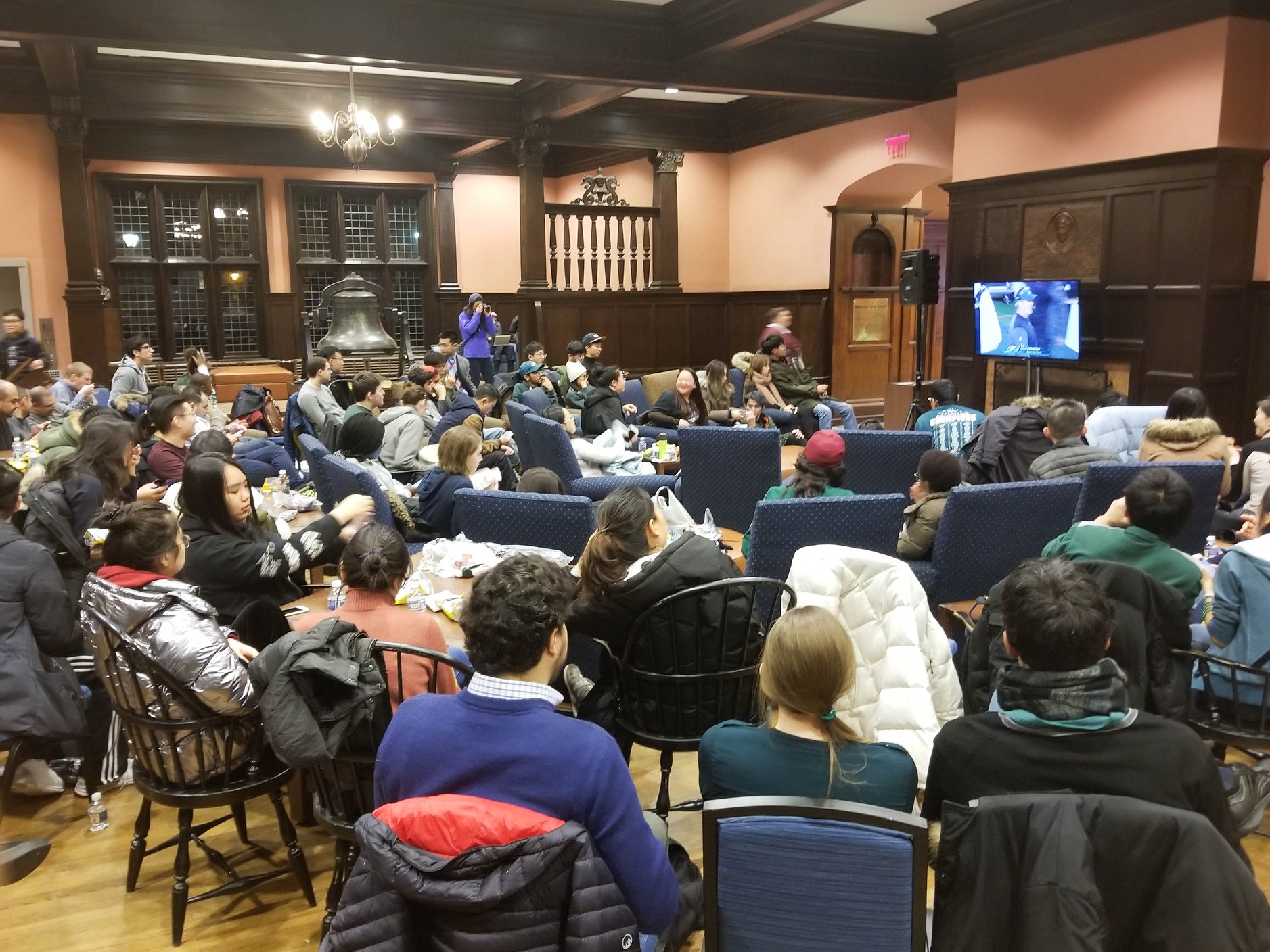 A crowd of Penn Students gather around a TV in the Penn Reading room to watch the Eagles play in the Super Bowl